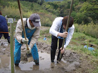 富士常葉大学の学生57人が石部の棚田に畦塗りボランティアに来ました